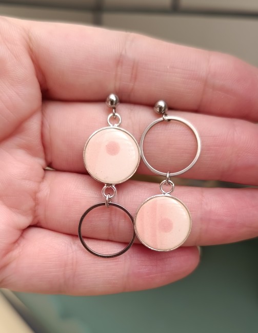 Boucles présentées en main pour apprécier les dimensions et les détails du motif.