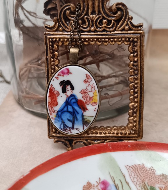 sautoir geisha fin et léger à porter Sautoir GEISHA tenu dans la main, détail des motifs japonais sur porcelaine ancienne, création artisanale française unique et poétique.