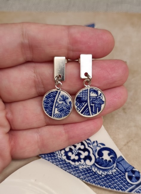 Gros plan sur les boucles d'oreilles Blue Willow mettant en valeur la finesse du décor bleu et blanc inspiré de la célèbre légende des deux amoureux