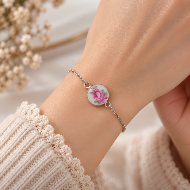 Détail du médaillon de 14 mm en porcelaine de Limoges aux pivoines roses, protégé sous une résine brillante transparente.