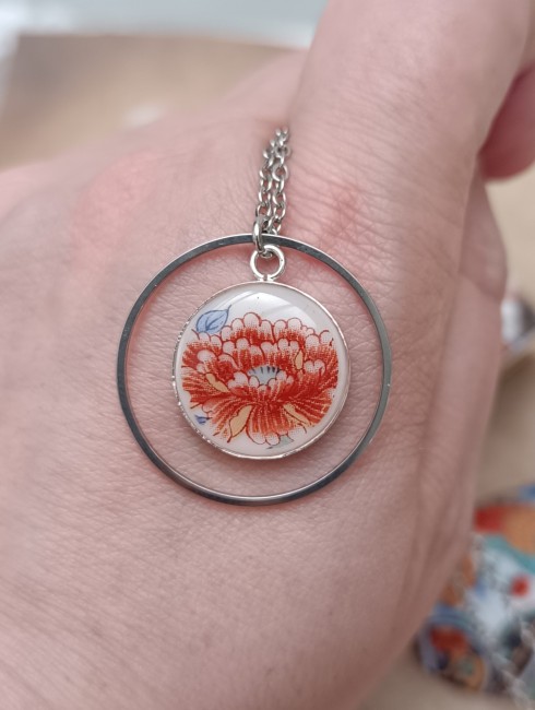 Collier Imari présenté en main pour visualiser le pendentif de 18 mm en porcelaine japonaise ancienne et son anneau de 30 mm.