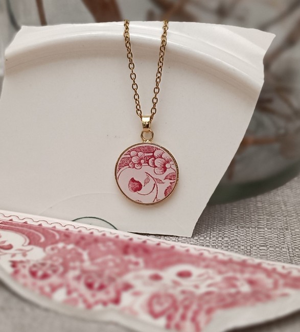 Collier porté avec pendentif en porcelaine vintage rouge grenadine et crème, monté sur support plaqué or 24 carats.