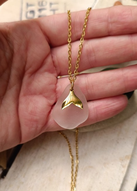 Zoom sur le verre de mer blanc aux reflets roses, poli naturellement par le sable et le temps.