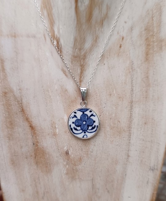 Visuel du collier en faïence de Moustiers porté. Pendentif 18 mm en plaqué argent, chaîne acier inoxydable 50 cm. Bijou artisanal issu d'une assiette ancienne sauvée.