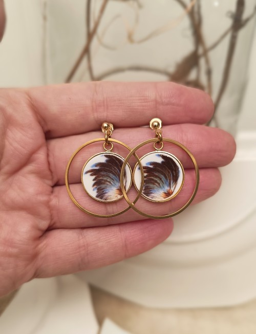 Pièces uniques façonnées à partir d’une sous-tasse ancienne. Plumes stylisées, montures plaqué or et acier inoxydable. Un bijou upcyclé au design moderne, réalisé à la main à Calais.