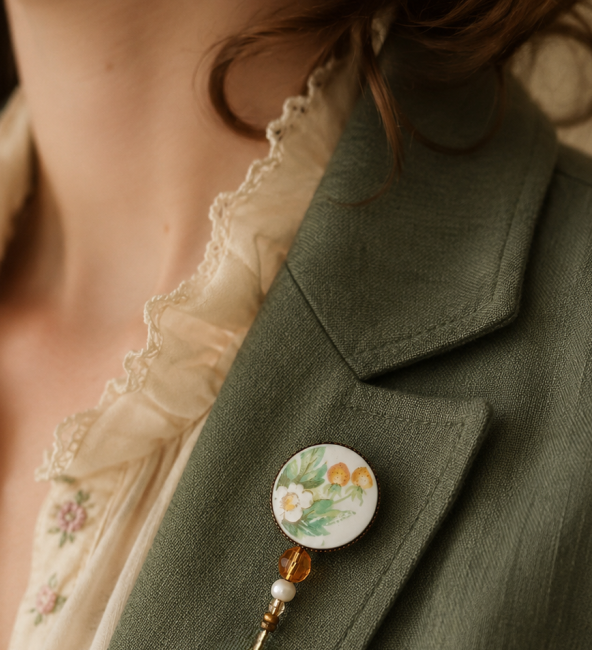 Broche textile en porcelaine anglaise vintage portée sur une veste ou un manteau.