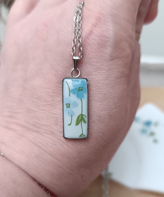 Collier Myosotis rectangulaire dans la main, format 30 x 10 mm.