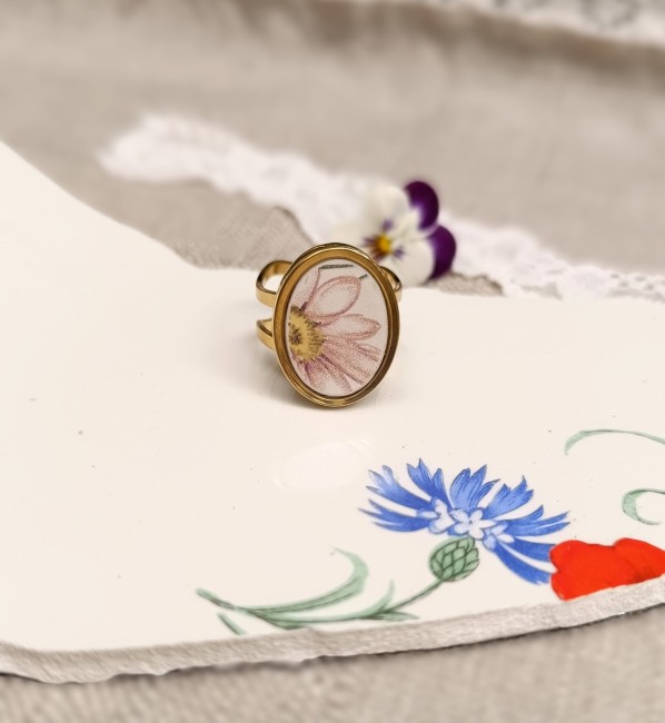 Bague ovale en faïence ancienne L'Amandinoise recyclée sur fond blanc, montée sur un support réglable en acier inoxydable doré.