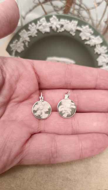 Détail des boucles Scarlet – Wedgwood Jasperware vert jade Boucles Scarlet tenues dans la main, détail des reliefs blancs néoclassiques sur fond vert jade, création artisanale française unique.