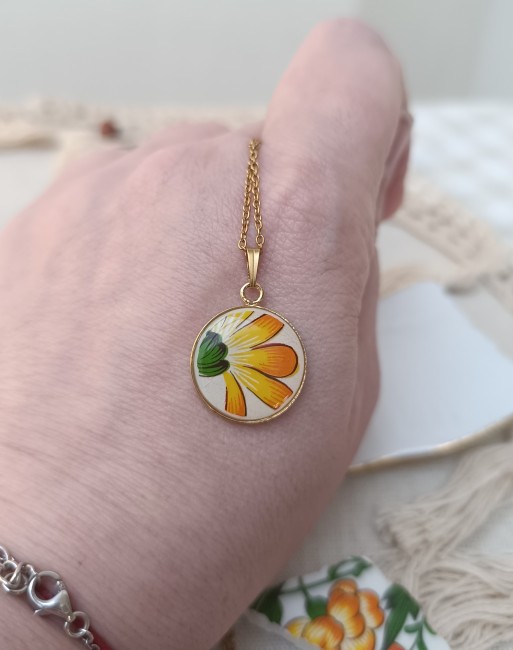 Gros plan sur la fleur jaune découpée dans une assiette en faïence de Gien.