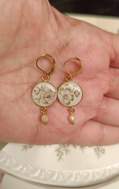 Gros plan sur les boucles d'oreilles Trianon mettant en valeur le décor délicat de la porcelaine ancienne et les perles irisées.