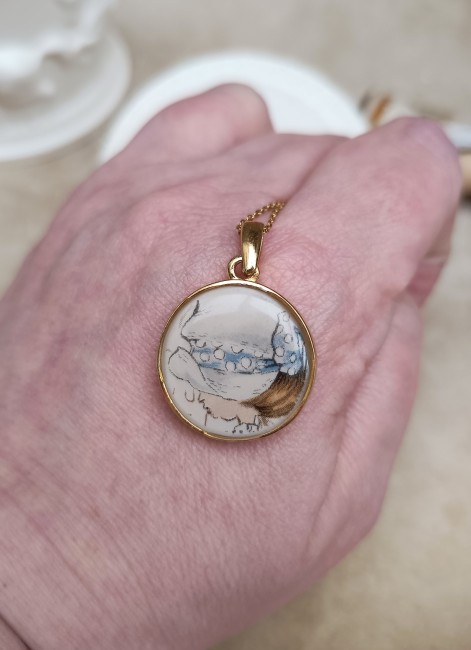 Détail motif du collier Sarah Kay – Porcelaine sculptée scellée Zoom sur le pendentif en porcelaine ancienne, sculpté et scellé dans la résine pour sublimer le motif Sarah Kay.