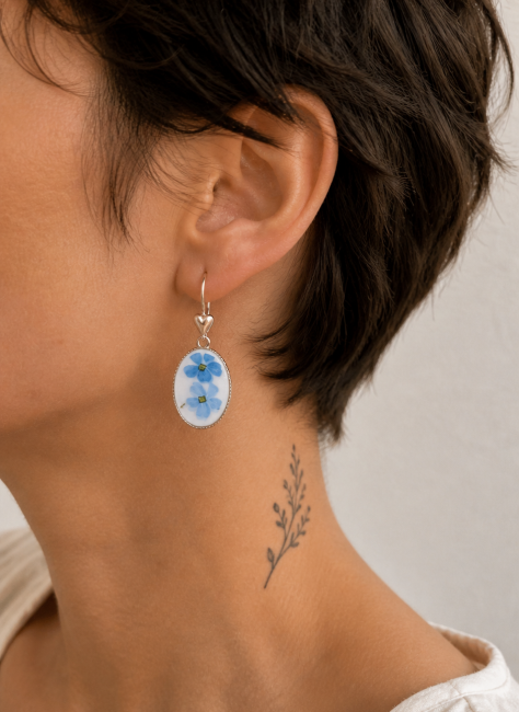 Boucles Myosotis portées, bijou en argent recyclé et verre opalin aux fleurs bleues.