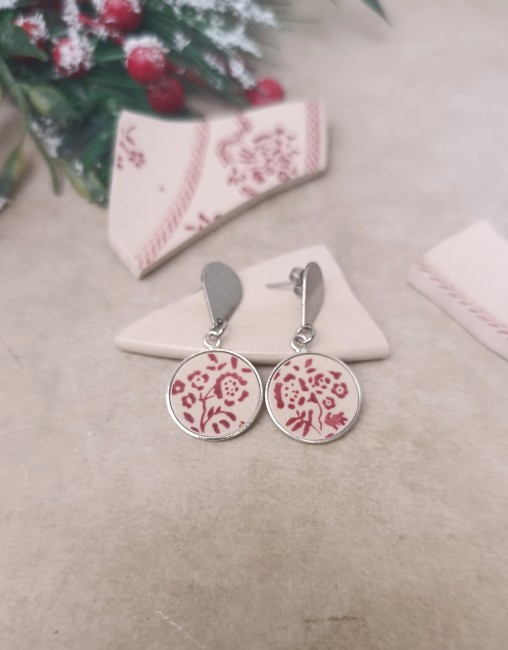 Détail des boucles d’oreilles Siropi en porcelaine recyclée Boucles d’oreilles Siropi tenues dans la main, détail du motif floral rouge grenadine sur porcelaine anglaise , création artisanale française.