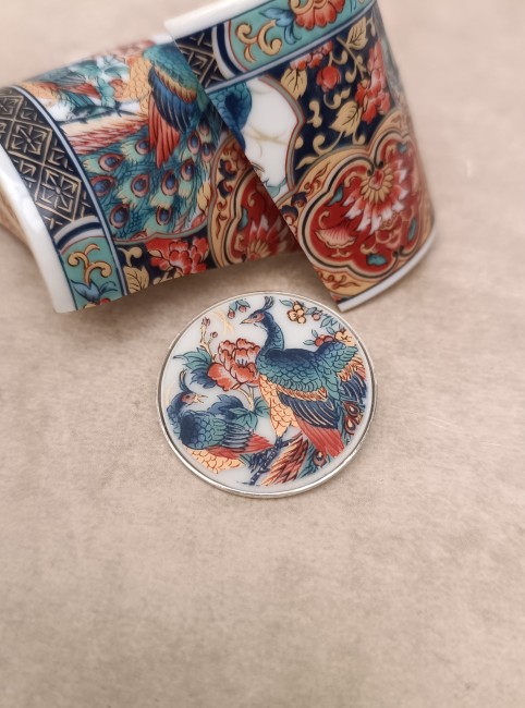 Broche artisanale en porcelaine japonaise Irami posée sur un fond clair, création française upcyclée.