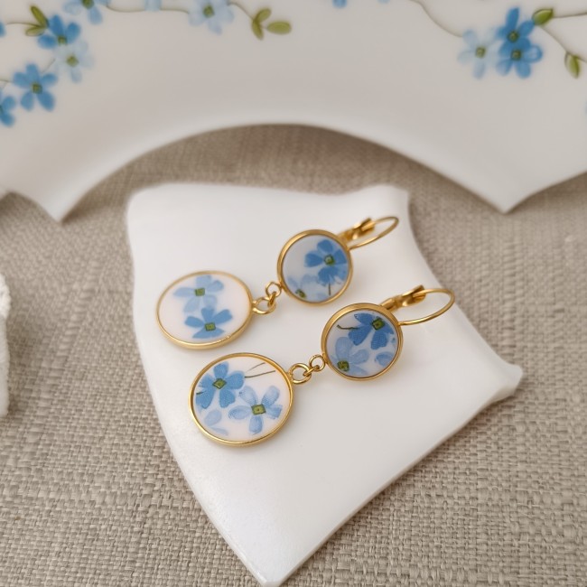 Boucles Myosotis vues en angle, jeu de volumes entre cabochon 12 mm et cabochon 16 mm.
