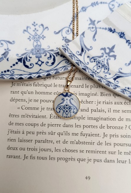 Visuel du collier en faïence de Moustiers porté. Pendentif 18 mm en plaqué or, chaîne acier inoxydable 50 cm. Bijou artisanal issu d'une assiette ancienne sauvée.