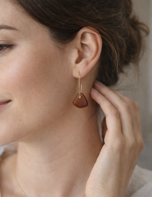 Créoles portées, format léger avec verre de mer lumineux aux teintes chaudes.