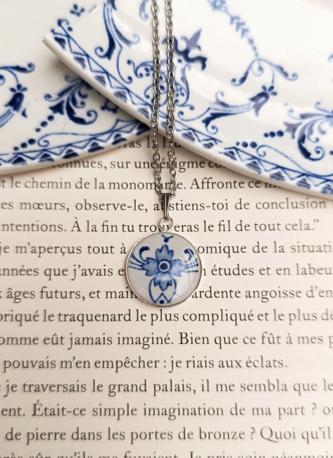 Pendentif artisanal créé dans le décor bleu d’une faïence ancienne française avec monture plaquée argent.