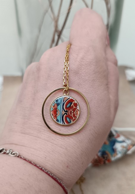 Collier Imari tenu à la main, montrant la délicatesse des fragments de porcelaine japonaise ancienne transformés en bijou contemporain.