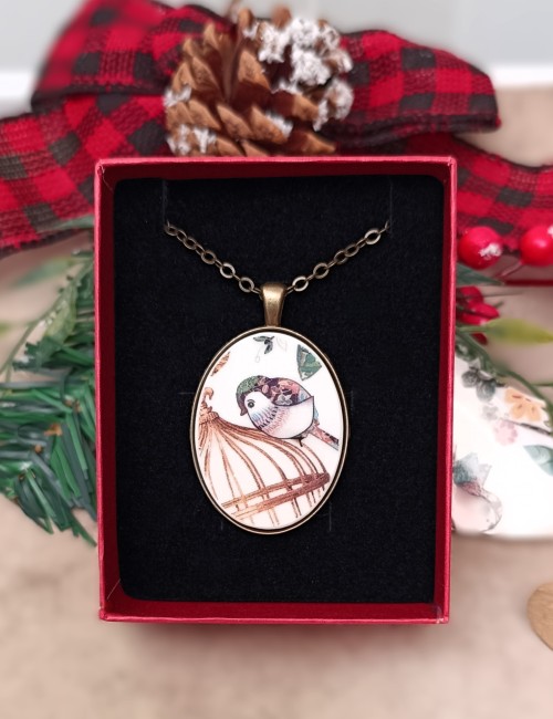 Photo du collier À la Volette sur écrin. Bijou-femme en porcelaine ancienne, pendentif ovale en laiton antique, création artisanale française, parfait pour Noël.