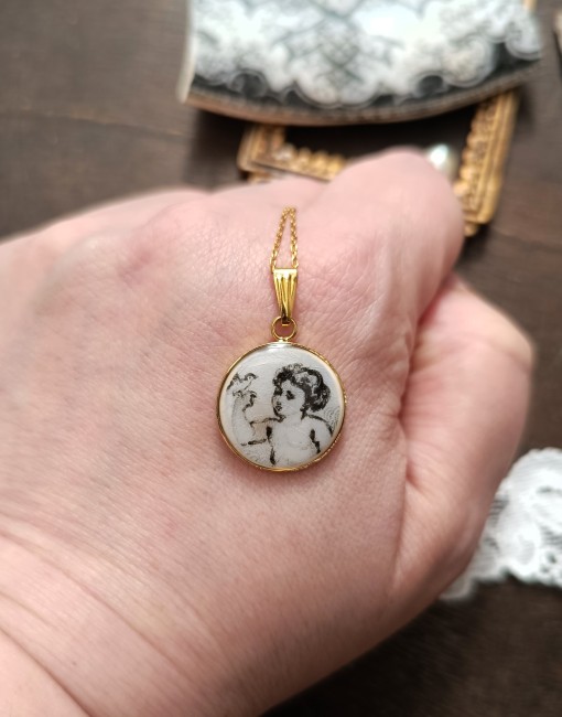 collier-relique-angelot-oiseau-detail-main