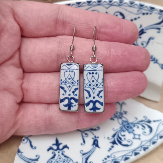 boucles-faience-ancienne--main Boucles en faïence ancienne présentées en main pour visualiser leurs supports rectangulaires de 10 × 30 mm.