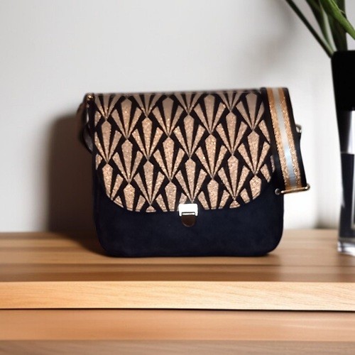 Sac à bandoulière "Palace" en suédine noire et rabat aux motifs dorés.