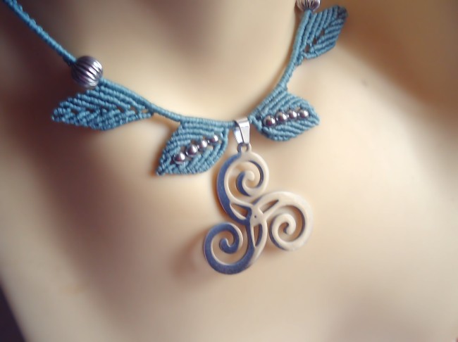 Collier en micromacramé vert et un triskel en acier inoxydable.