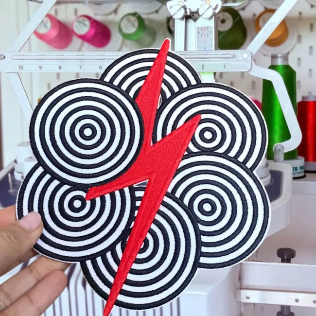 Ecusson grand format du motif cercles hynotique avec un clair rock rouge au centre Patch éclair avec cercles hypnotiques dans mon atelier
