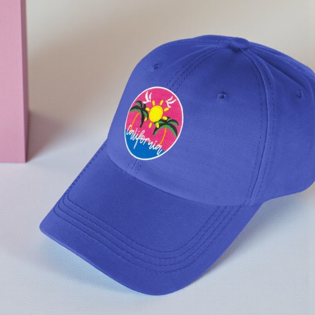 Patch brodé California cousu sur une casquette bleue, palmiers et soleil rose