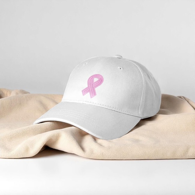 Casquette blanche avec écusson brodé ruban rose appliqué, exemple d'utilisation sur accessoire. Patch ruban rose brodé en fil Oeko-Tex, parfait pour vestes, casquettes ou hoodies.