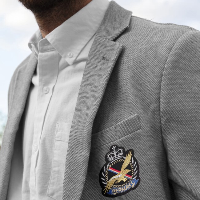 Écusson blason aigle Germany brodé porté sur blazer gris homme Patch brodé Germany porté sur une veste chic pour un look royal