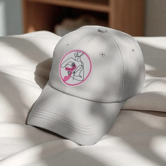 Patch brodé ruban rose sur une casquette blanche, symbole d’Octobre Rose 