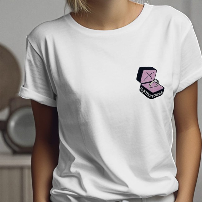 Écusson bague brodée rose poudré sur un tee-shirt blanc