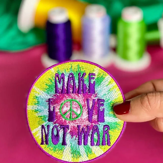 Patch brodé tie-dye prise en photo dans mon atelier Patch Make Love Not War brodé dans mon atelier