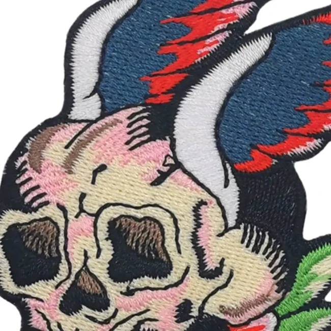 Détail broderie Oeko-Tex style old school Gros plan sur la broderie du patch tête de mort ailée