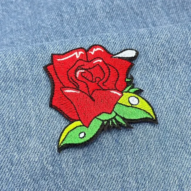 écusson rose rouge posé sur un jean bleu
