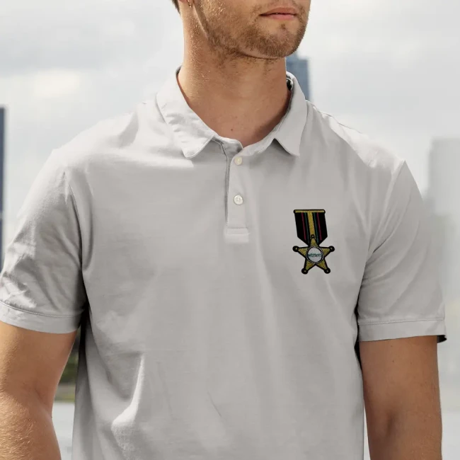 Écusson médaille brodé porté sur un polo Patch médaille dorée appliqué sur un polo blanc