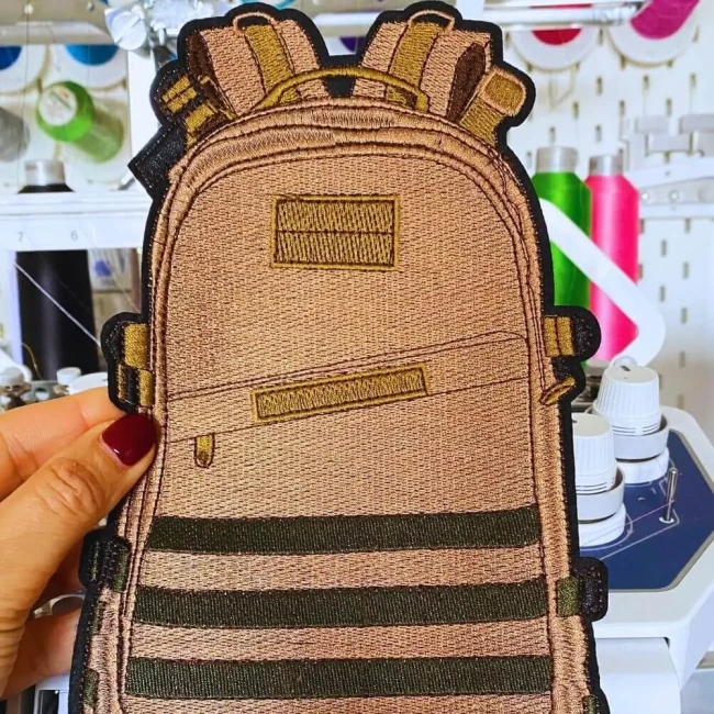 Grand patch sac à dos brodé présenté dans un atelier