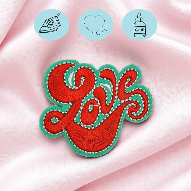Patch LOVE brodé en rouge et vert thermocollé sur tissu rose