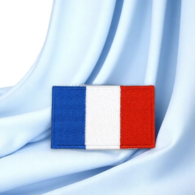 Écusson rectangle bleu blanc rouge photographié sur tissu satiné bleu ciel