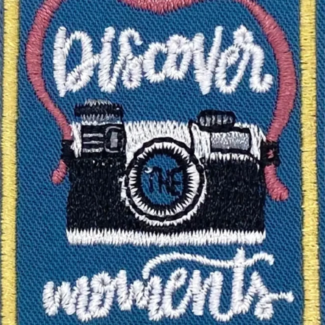 Gros plan sur la broderie du patch Discover Moments