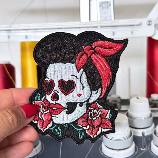 Écusson original pin-up crâne rouge, photographié dans mon atelier de broderie Vue rapprochée de broderie pin-up rock mexicaine