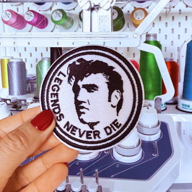 Ecusson brodé Elvis Presley fabriqué dans mon atelier de broderie Patch brodé Elvis Presley Legends Never Die tenu devant une machine à broder
