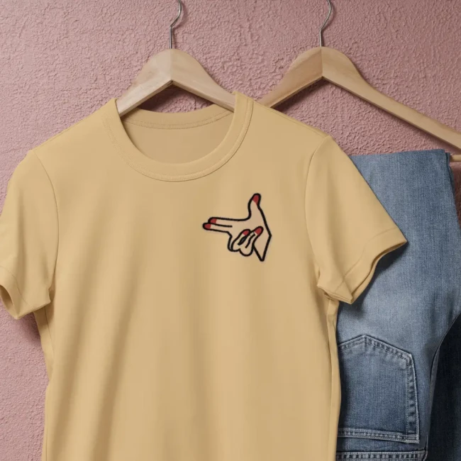 Patch main pistolet rétro posé sur un tee-shirt beige