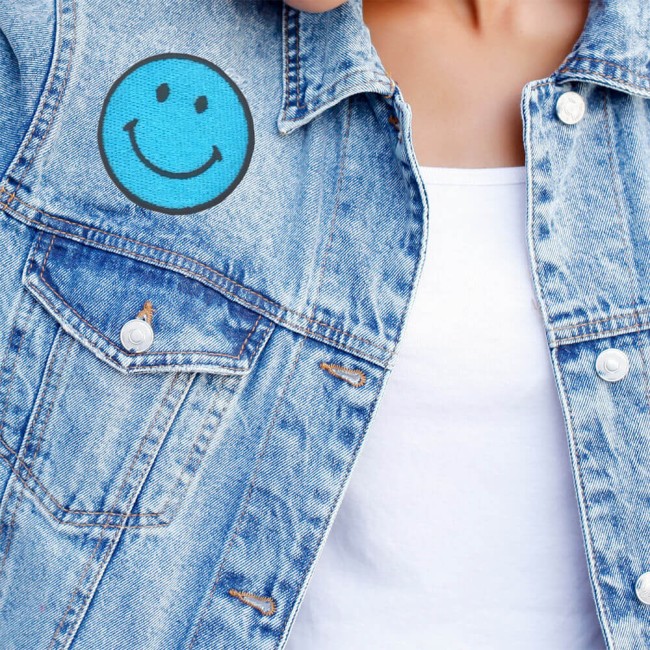 Patch smiley bleu turquoise posé une veste en jean bleu délavé