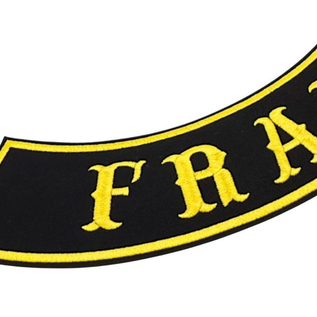 Zoom broderie patch biker Gros plan sur une bannière biker brodée noire et jaune avec lettres en relief et bordure brodée