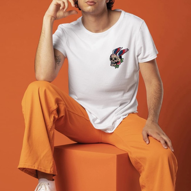 Crâne ailé avec fleur brodé main sur un t-shirt blanc