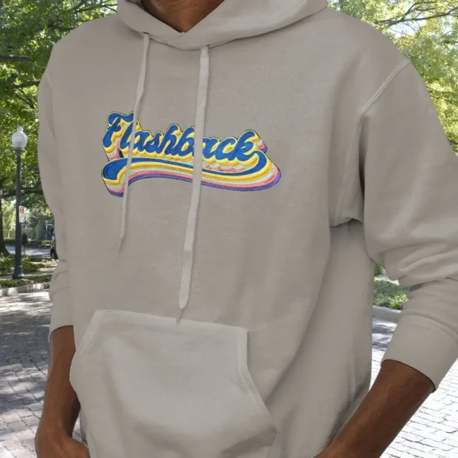 Sweatshirt gris porté un jeune homme customisé avec le grand patch flashback qui a été cousu Patch Flashback 100% brodé sur le devant d'un hoodie gris clair